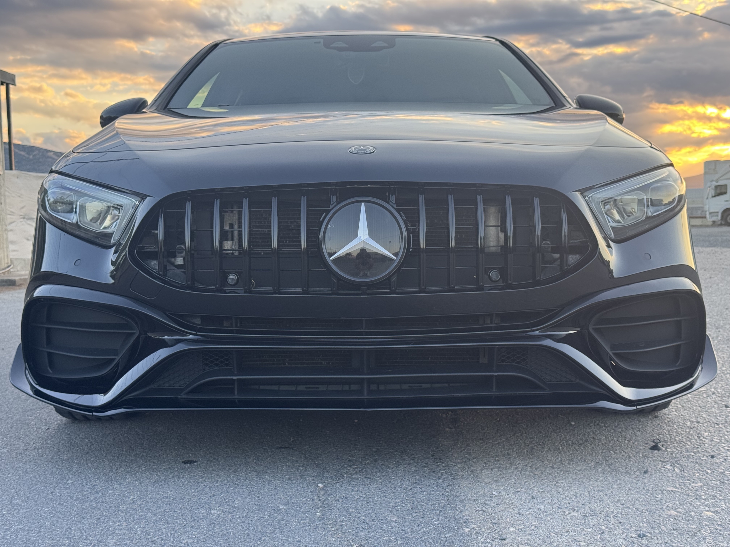 Μαύρη Mercedes μπροστινή όψη στο ηλιοβασίλεμα